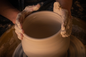 person holding white clay pot